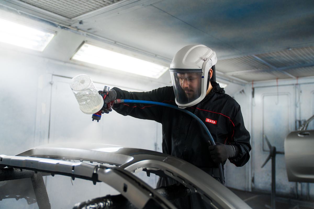 Lackierer bei der Arbeit in der Lackierkabine
